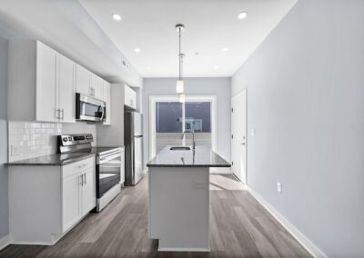 Renovated kitchen with island, stainless steel appliances, and sliding glass doors to balcony