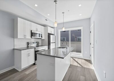 Newly renovated kitchen with stainless appliances, an island, large windows, and recessed lighting